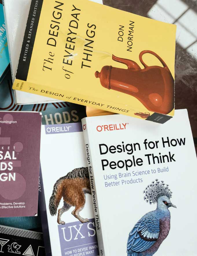Stack of books with tips for designing a great logo. Photo by Karl Solano on Unsplash